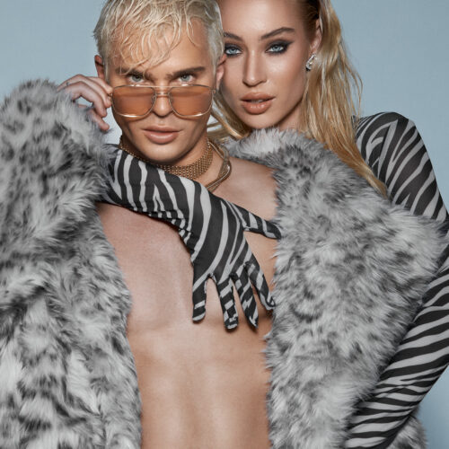 Fashion photography male and female models. Male in Fur coat model in striped dress