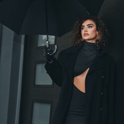 fashion photography female model in a black coat with umbrella